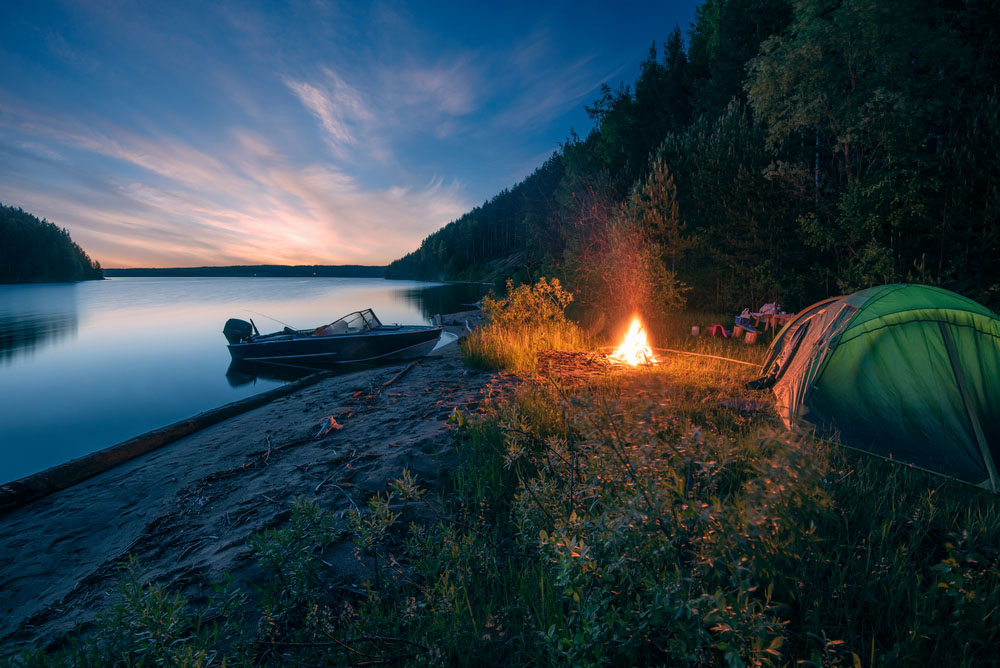 tent on riverbank with boat