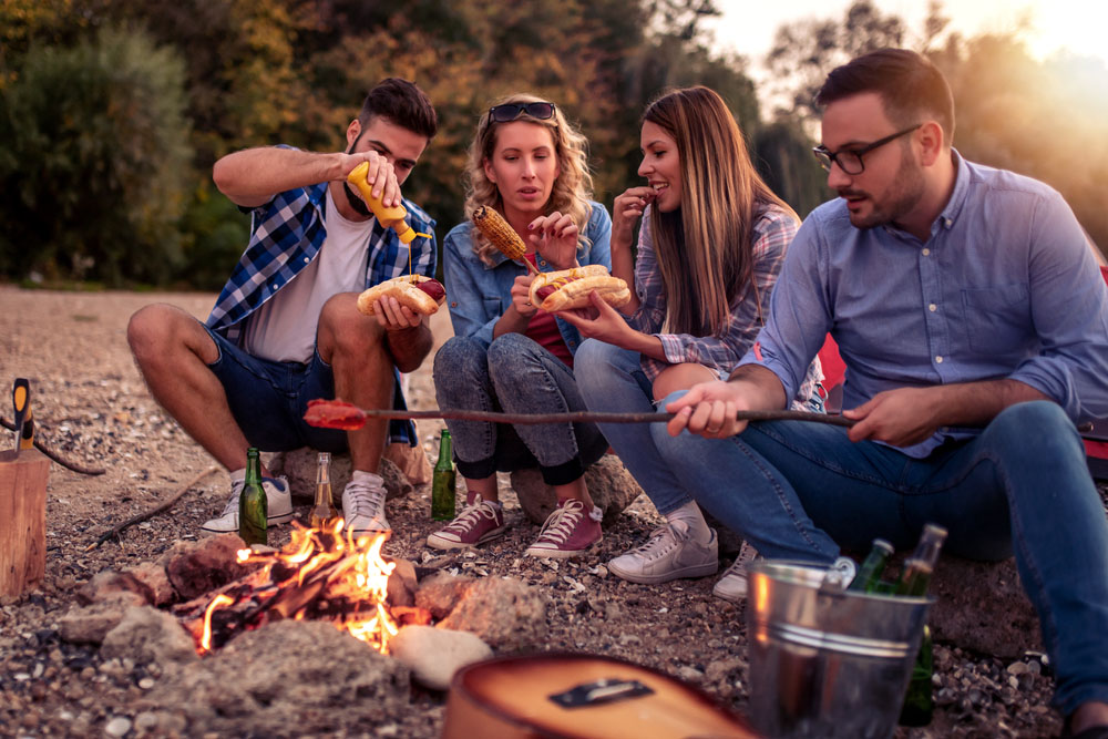group of friends cooking on a campfire
