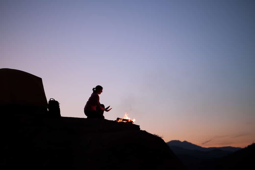 woman camping by the fire