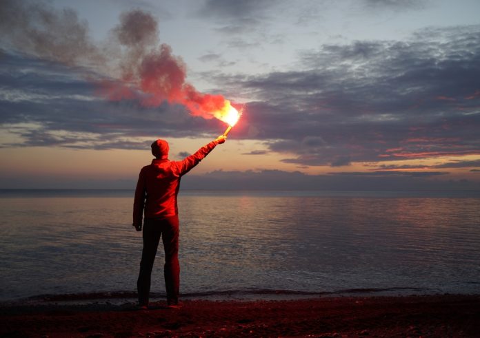Man on a Beach Holding an Emergency Flare