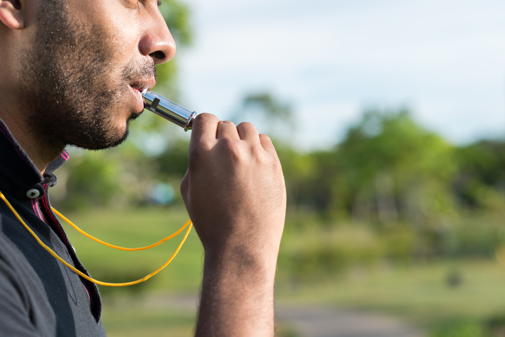 Person blowing a rescue whistle