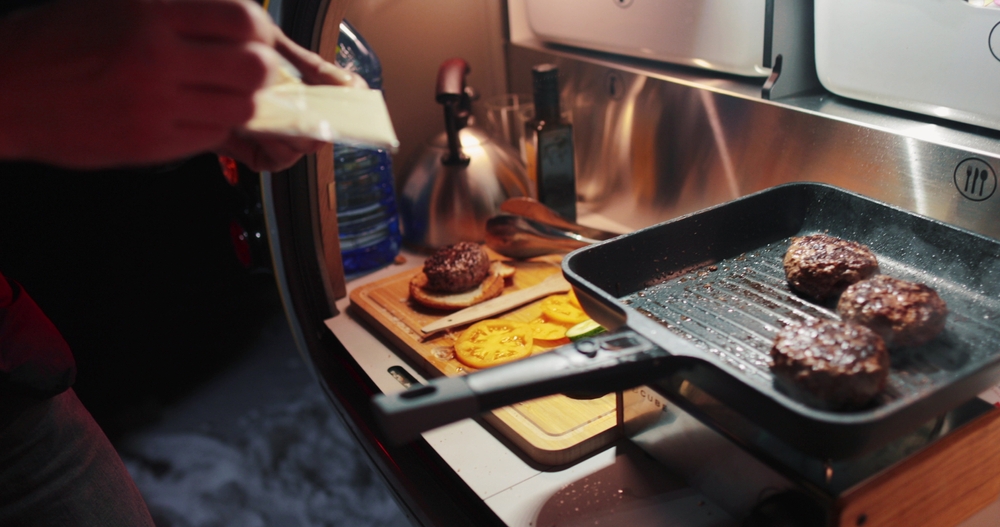 cooking hamburgers in a trailer galley