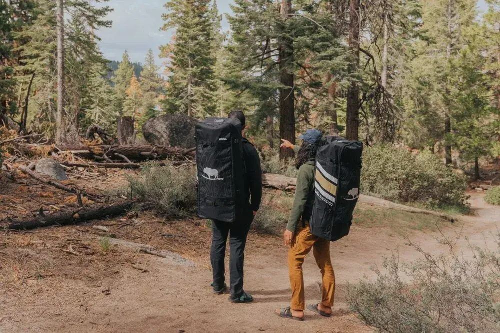 hikers with atoll 11 ft paddle boards in backpacks
