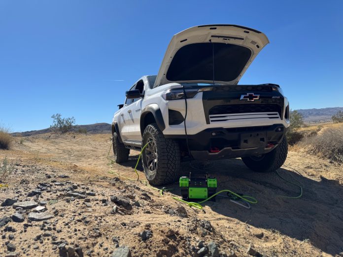 Morrflate TenSix air compressor with hoses connected inflating tires on a white Chevy Colorado ZR2 in the desert