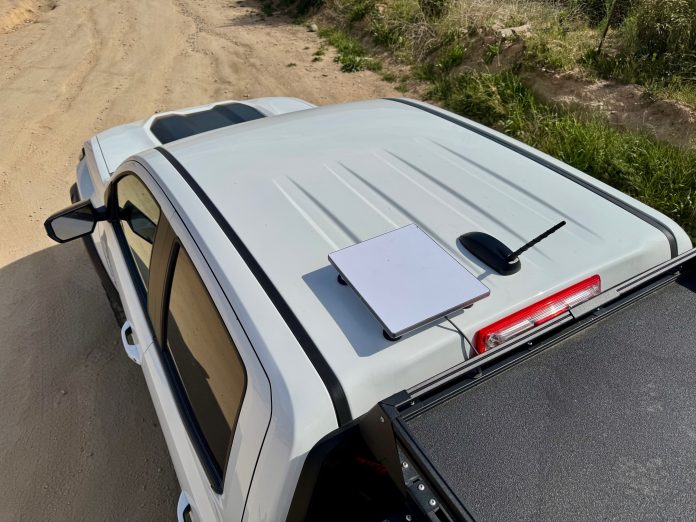Overhead view of a Starlink dish mounted on a truck roof rack using a Flagpole Buddy roof mount