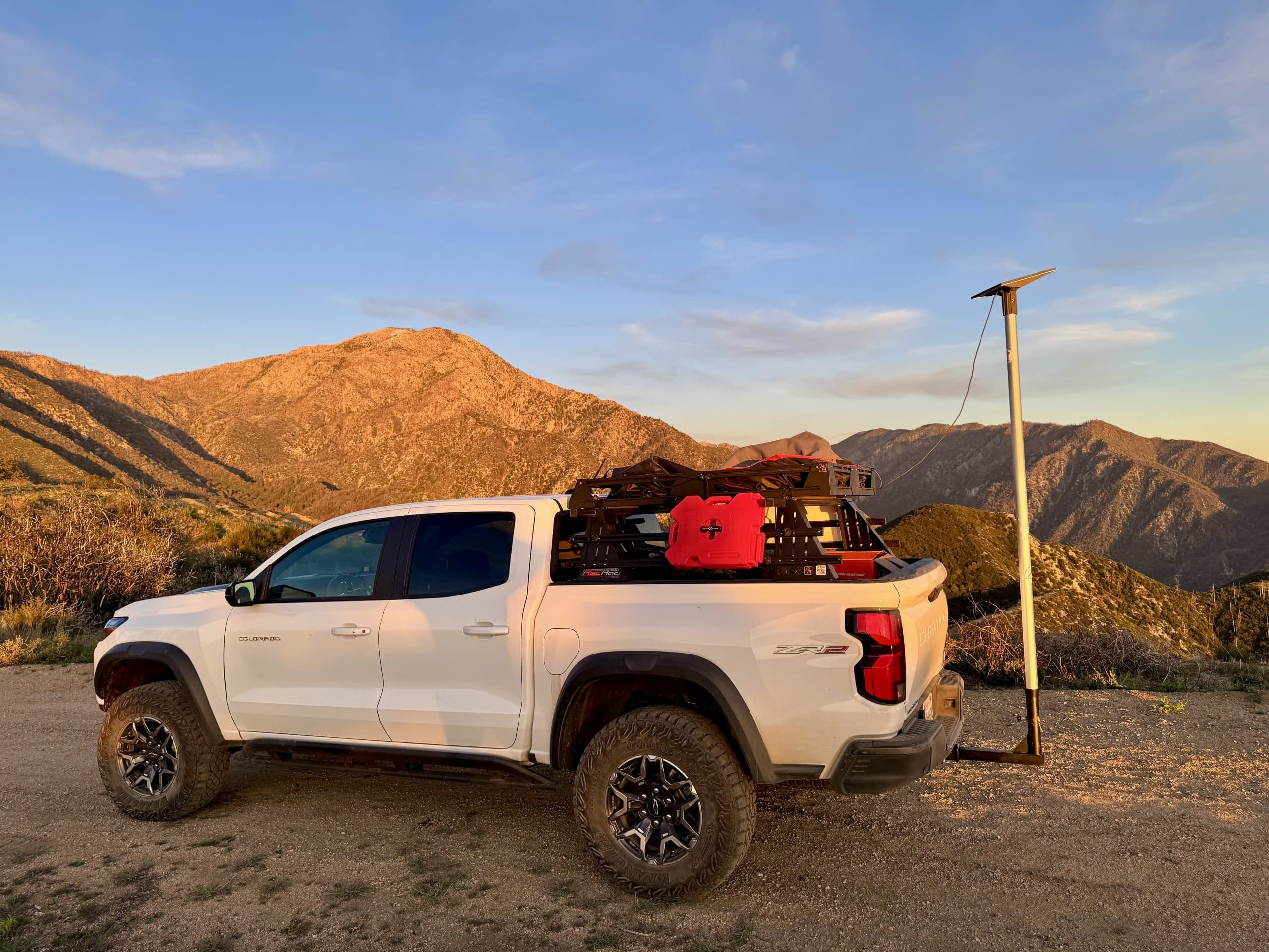 White Chevy Colorado ZR2 parked on a mountain overlook with a Starlink Mini mounted on a pole antenna
