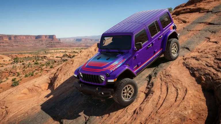 Purple Jeep Wrangler Rewind 2026 Mojave edition with retro stripe graphics parked on red rock terrain.