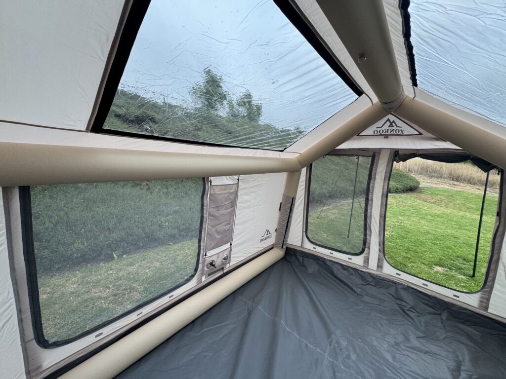 Interior corner view of the Zonkoo Orion inflatable tent showing the clear roof vent and mesh side windows