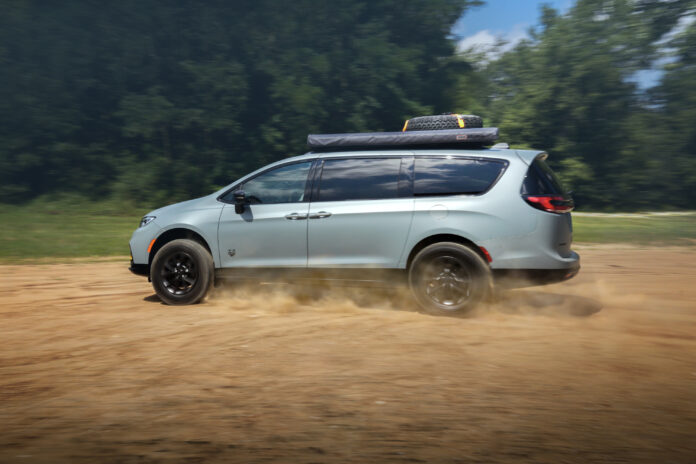 Light blue Chrysler Pacifica Grizzly Peak concept minivan kicking up dust while driving on a dirt road