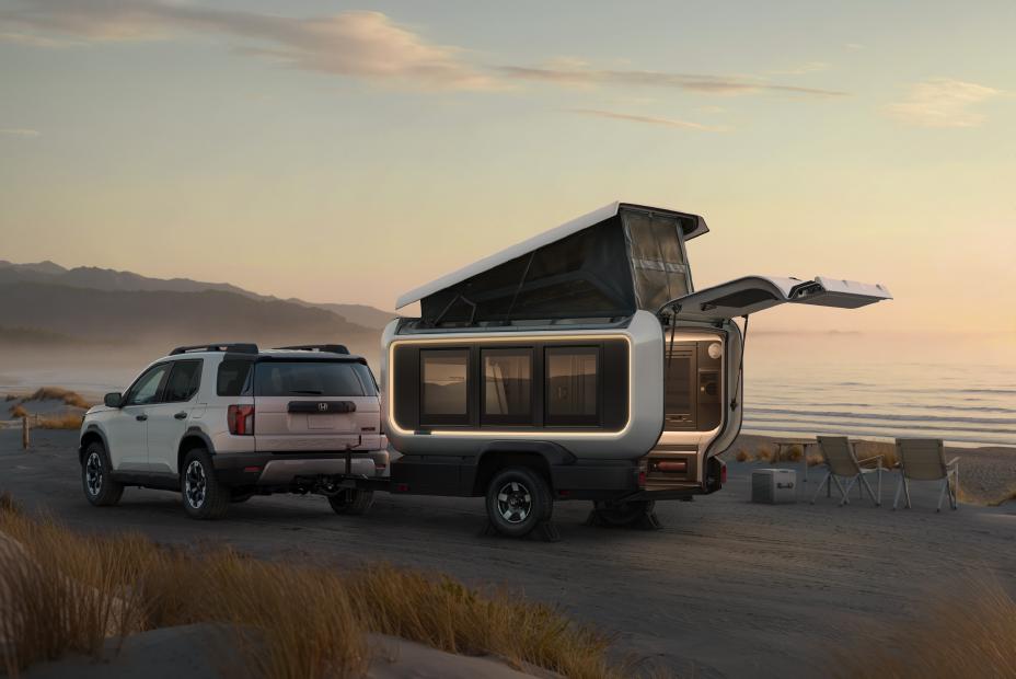 Honda Base Station camper trailer with pop-top roof raised and rear hatch open revealing a small kitchen — manufacturer image