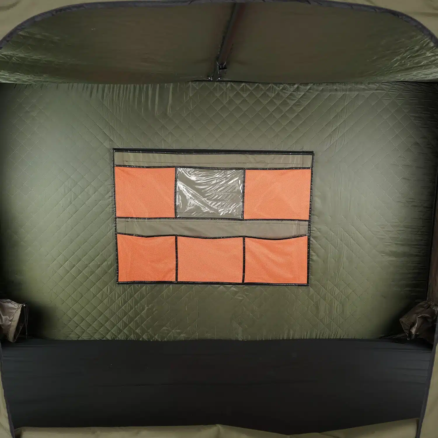 Interior rear wall of the Inspired Overland Trailpeak rooftop tent showing an orange mesh gear organizer panel