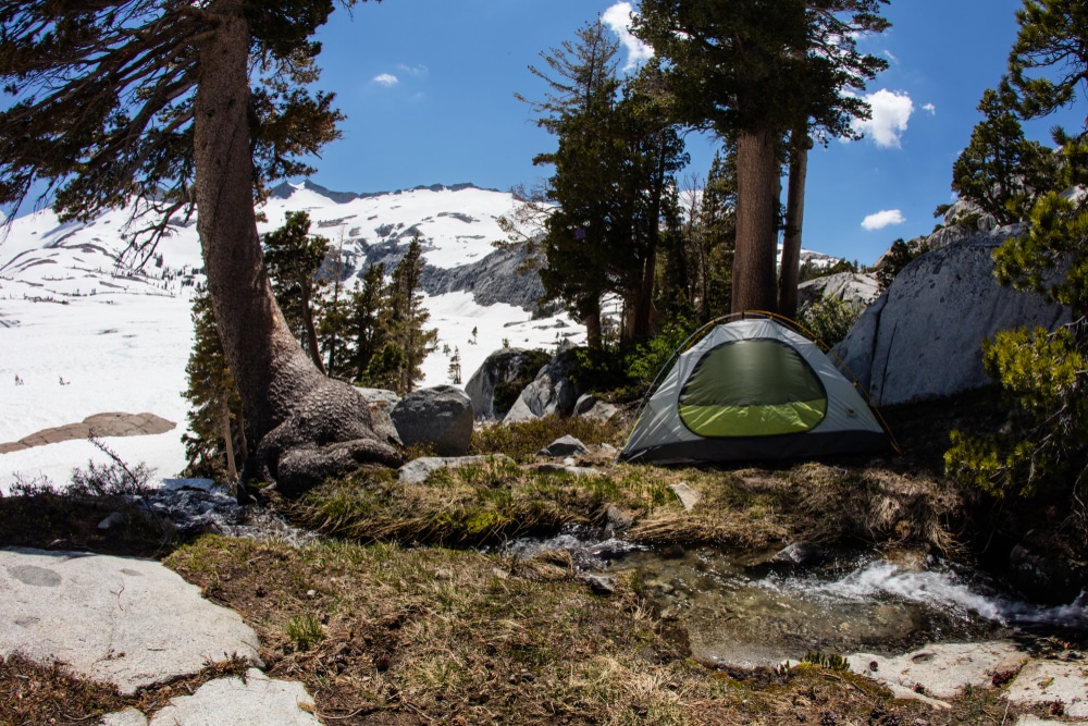 Bright sunlight falls on mountain campsite in California's Desolation Wilderness, not far from Lake Tahoe. This beautiful part of the Sierra Nevada Mountains is popular for camping and hiking.