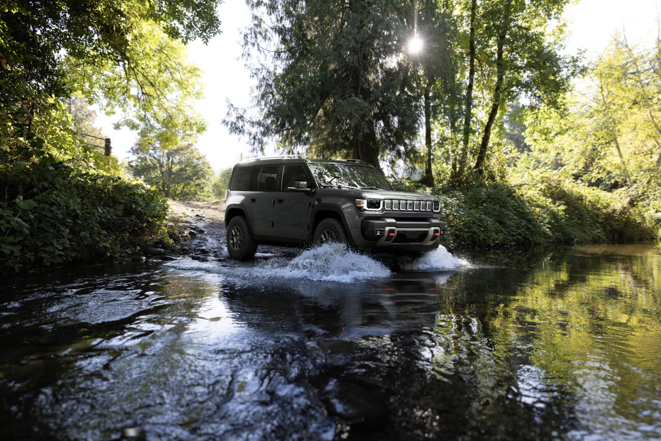 Gray 2026 Jeep Recon Trail Rated SUV fording a shallow forest stream