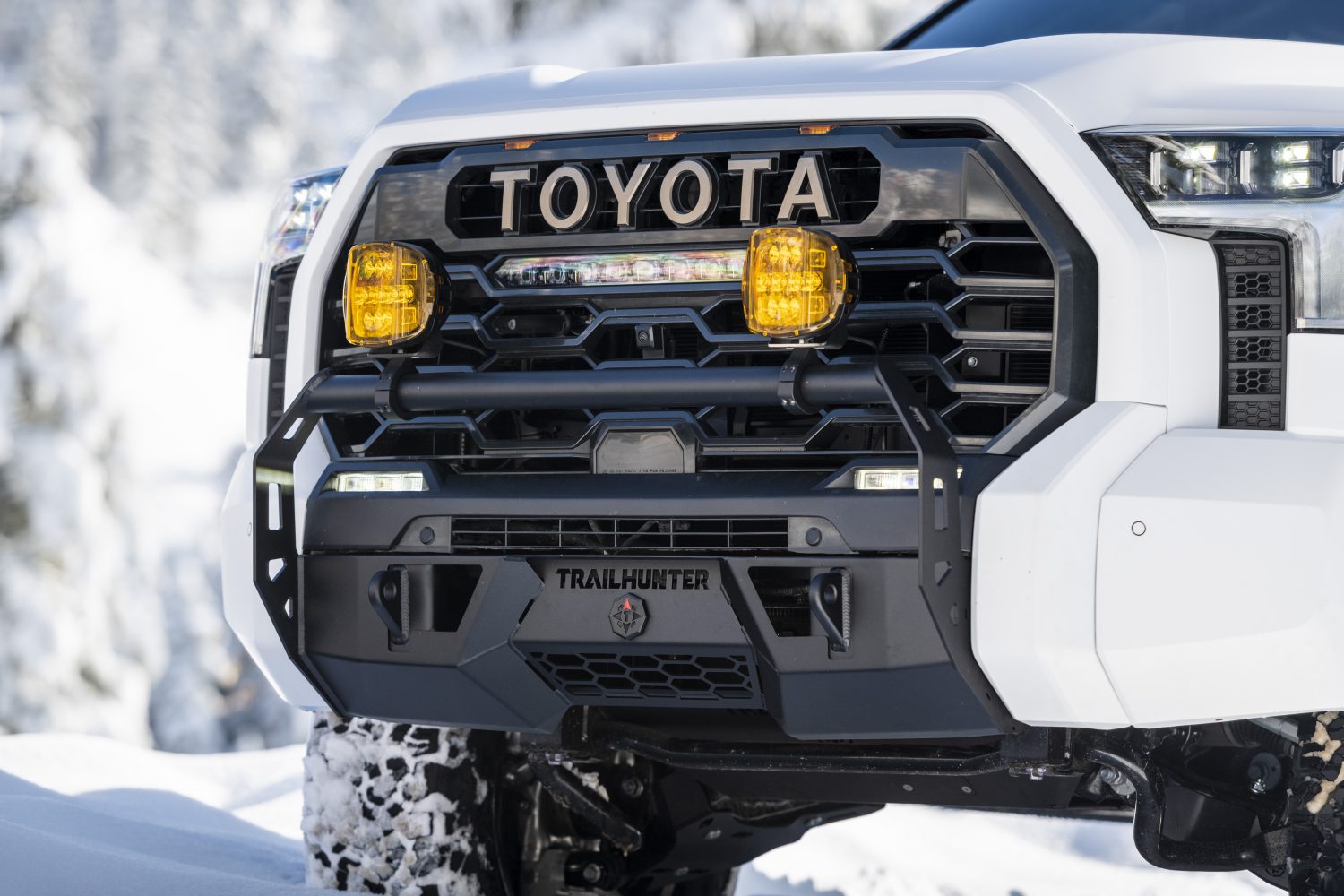 Close-up of the 2027 Toyota Tundra Trailhunter front grille with amber fog lights and Trailhunter badge