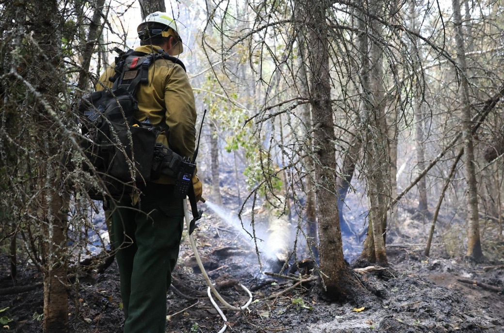 Firefighter mopping up hot spots on the Creek Fire during the Superior National Forest wildfire closure