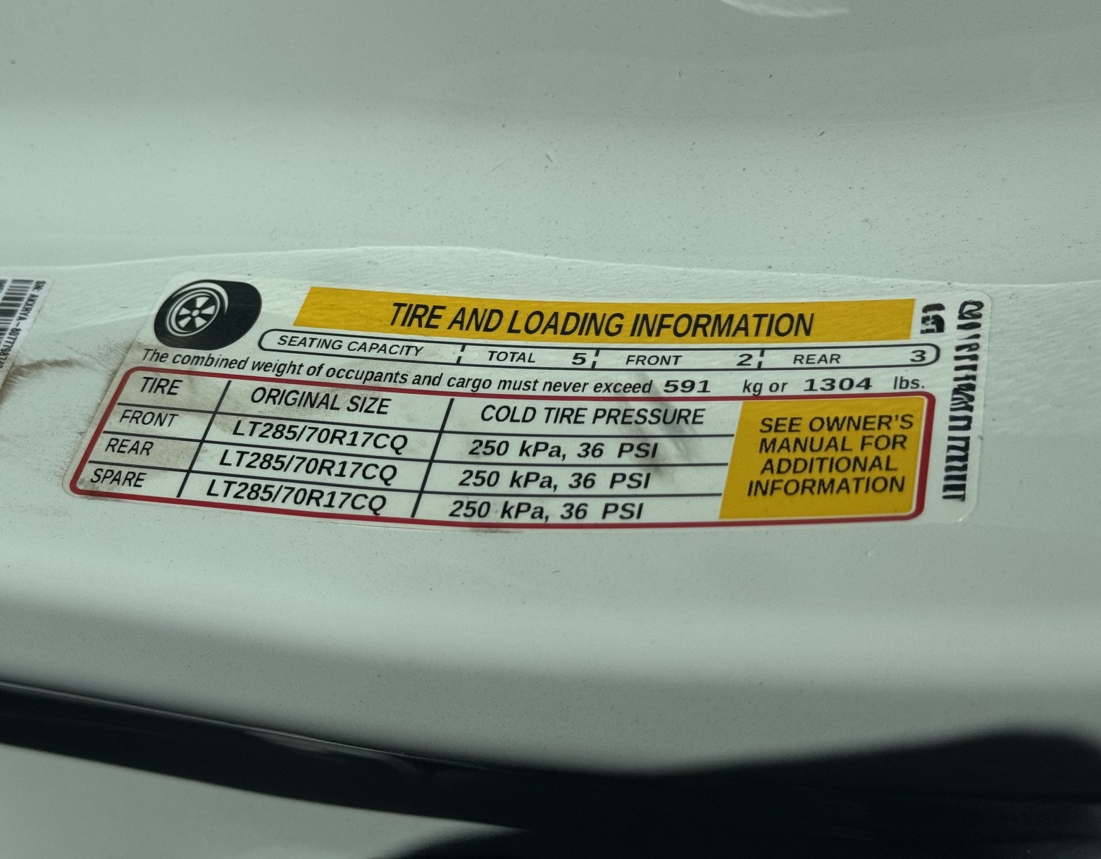 Door jamb placard showing vehicle capacity weight and tire pressures