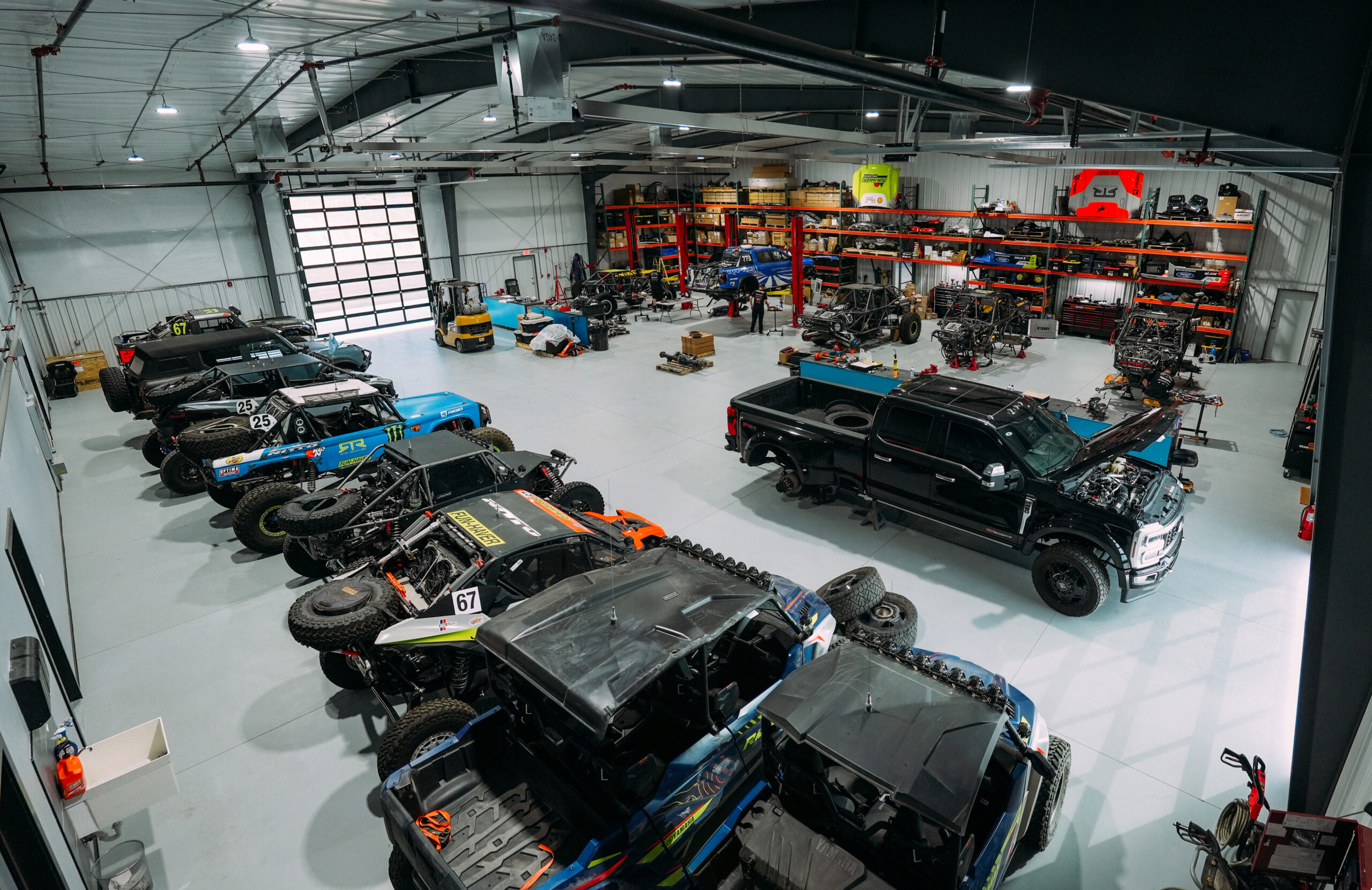 Ultra4 Bronco race trucks, UTVs, and a Ford Super Duty under service on the RTR shop floor in Farmington