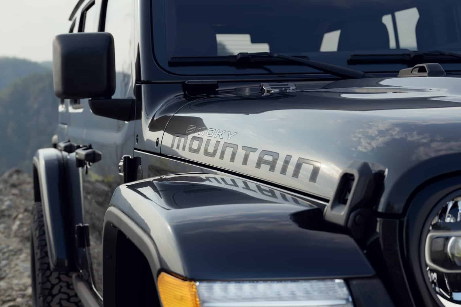 Close-up of the Smoky Mountain hood-side decal on a 2027 Jeep Wrangler, with the black fender flare and mirror in frame