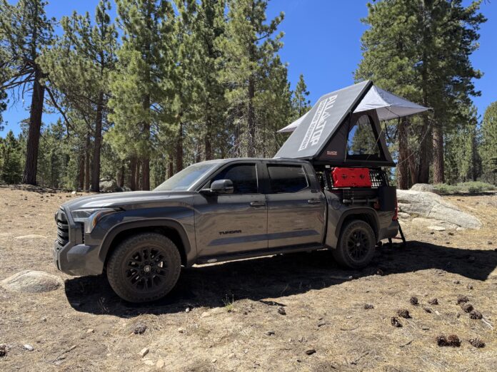 ALL-TOP Apexcamp rooftop tent open on a Toyota Tundra showing the branded side panel of the raised shell