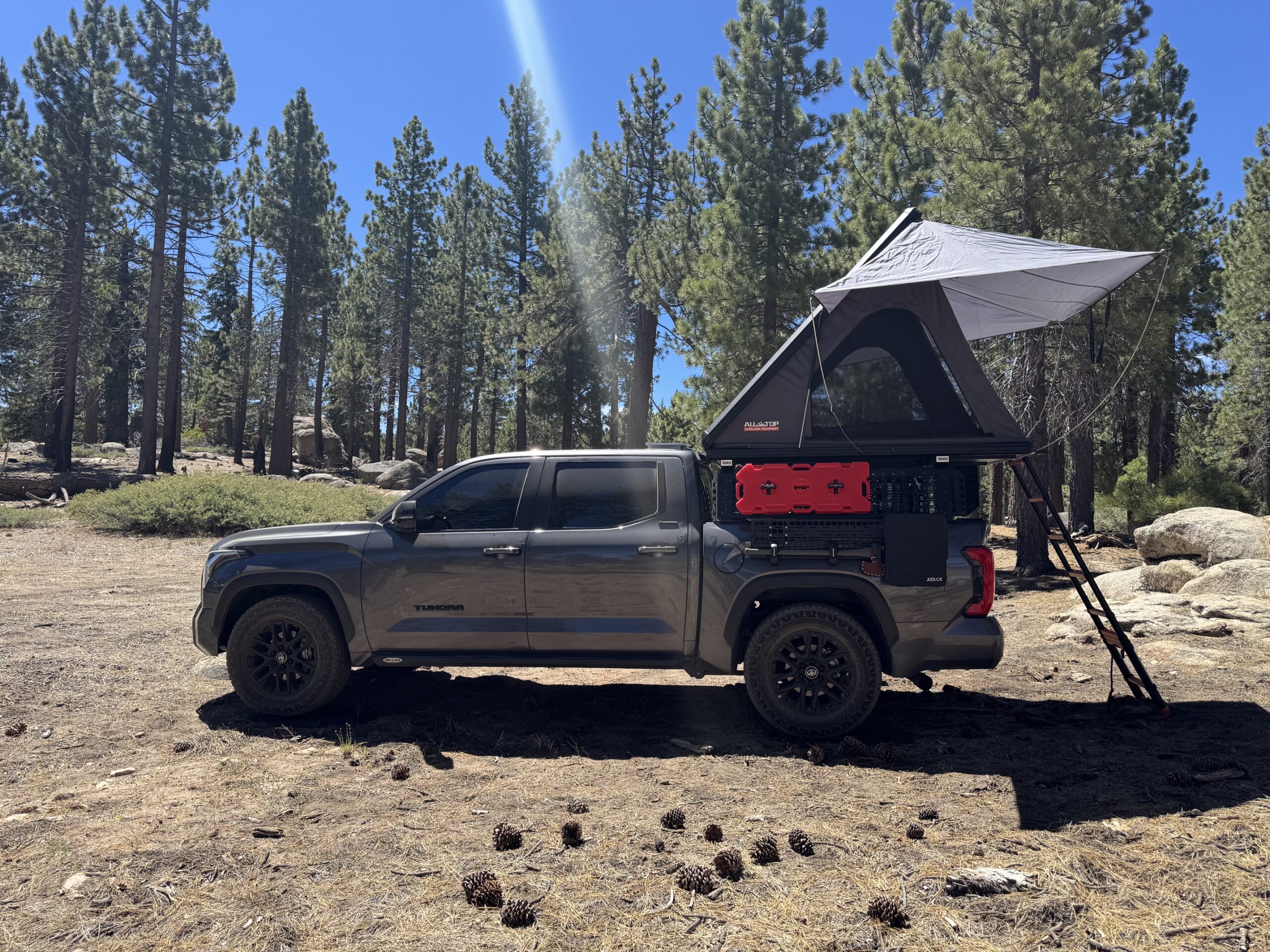 Side profile of the ALL-TOP Apexcamp rooftop tent open on a Toyota Tundra with the awning extended over the bed