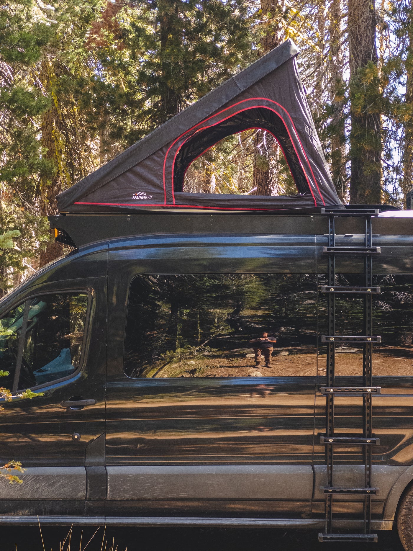 Featherlyte Baseline rooftop tent open on a van with the telescoping ladder mounted along the vehicle side