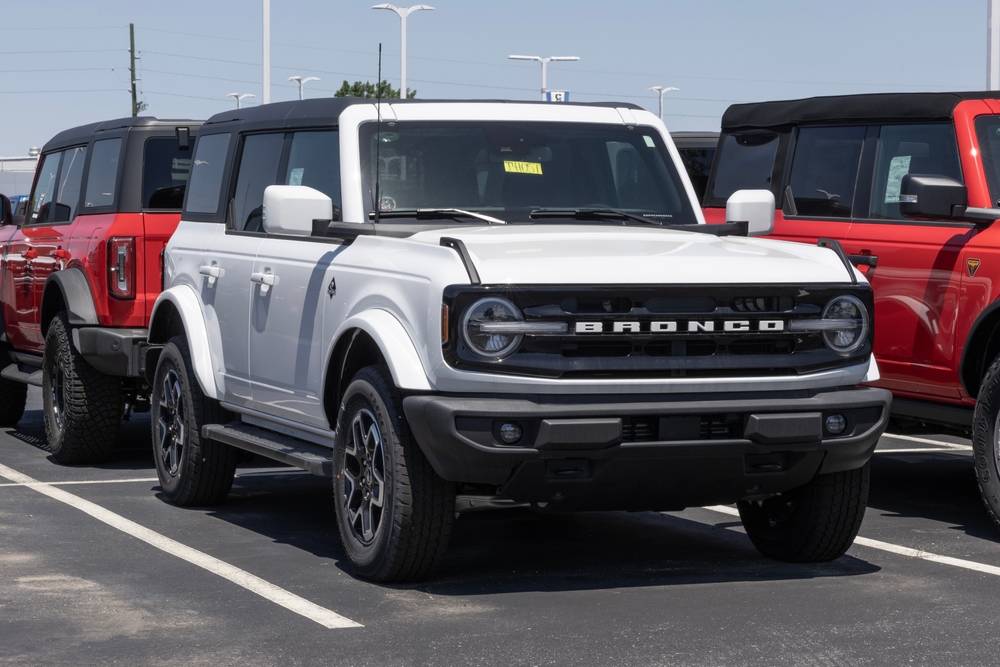 White Ford Bronco sitting on a dealership parking lot