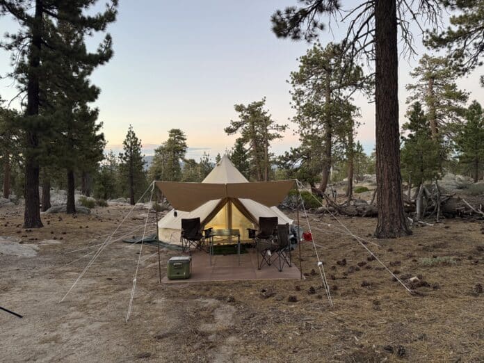velit-portable-heater-forest-campsite Canvas bell tent lit at dusk at a forest campsite