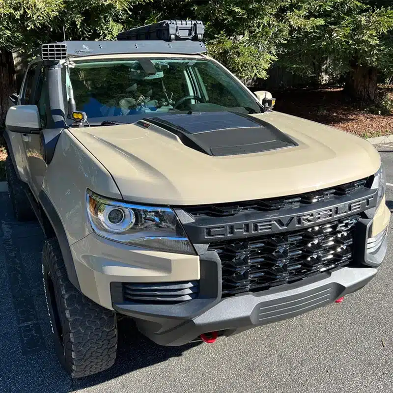 Black hood solar panel bonded over the hood scoop of a sand-colored Chevrolet Colorado ZR2