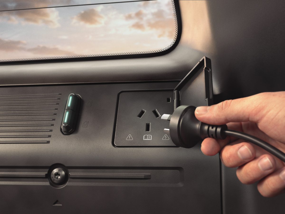 Hand plugging a power cord into a Pro Power Onboard outlet on the Bronco Basecamp