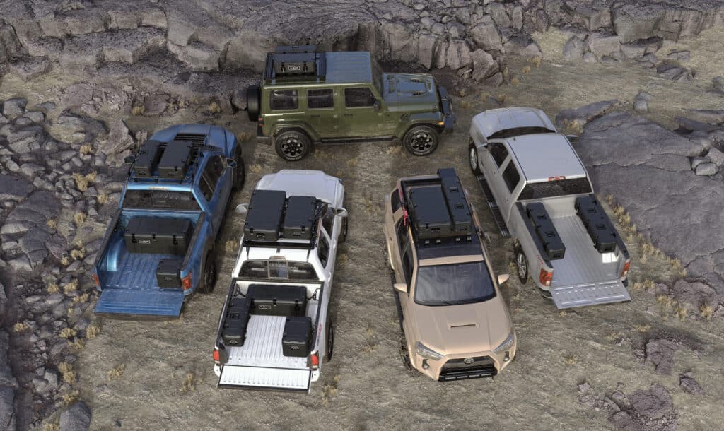Pelican Cargo cases on a Jeep Wrangler and pickup trucks Aerial view of a Jeep Wrangler and pickup trucks carrying Pelican Cargo overland storage boxes on roof racks and in beds