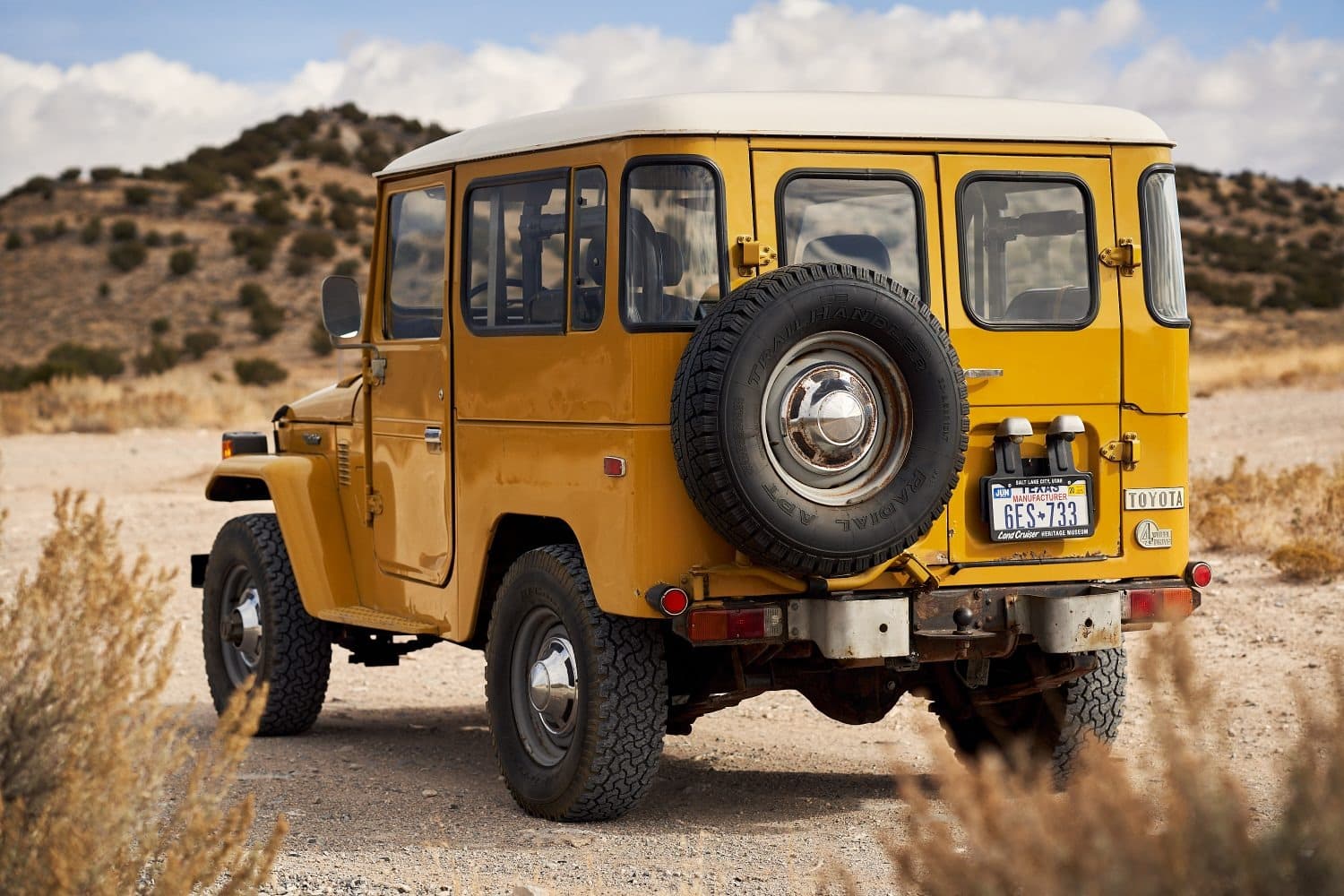 Toyota FJ40 Land Cruiser Rear view of a yellow 1977 Toyota FJ40 Land Cruiser with its spare tire on the back door, a 1976 to 1980 classic in the first exemption wave