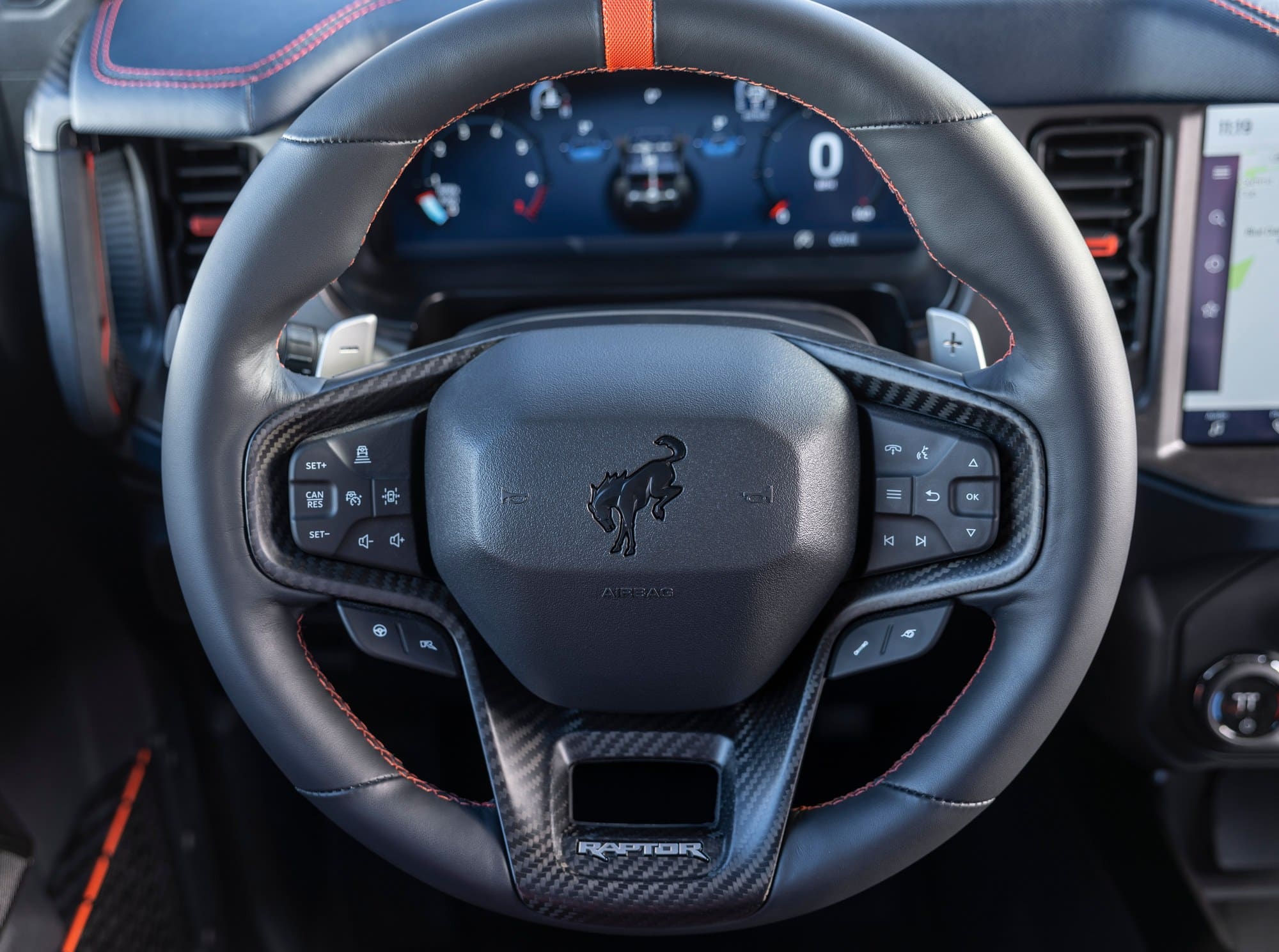 2022 Ford Bronco Raptor steering wheel (Ford press photo) Steering wheel and digital gauge cluster of the 2022 Ford Bronco Raptor with orange stitching