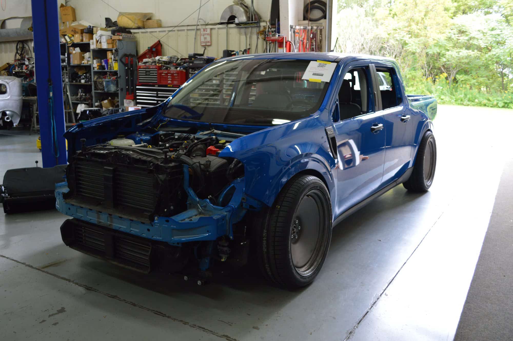 Ford Maverick V8 Build in the Tucci Hot Rods Shop Blue Ford Maverick XLT in the Tucci Hot Rods shop with its bumper cover, grille and headlights removed, exposing the radiator and engine bay