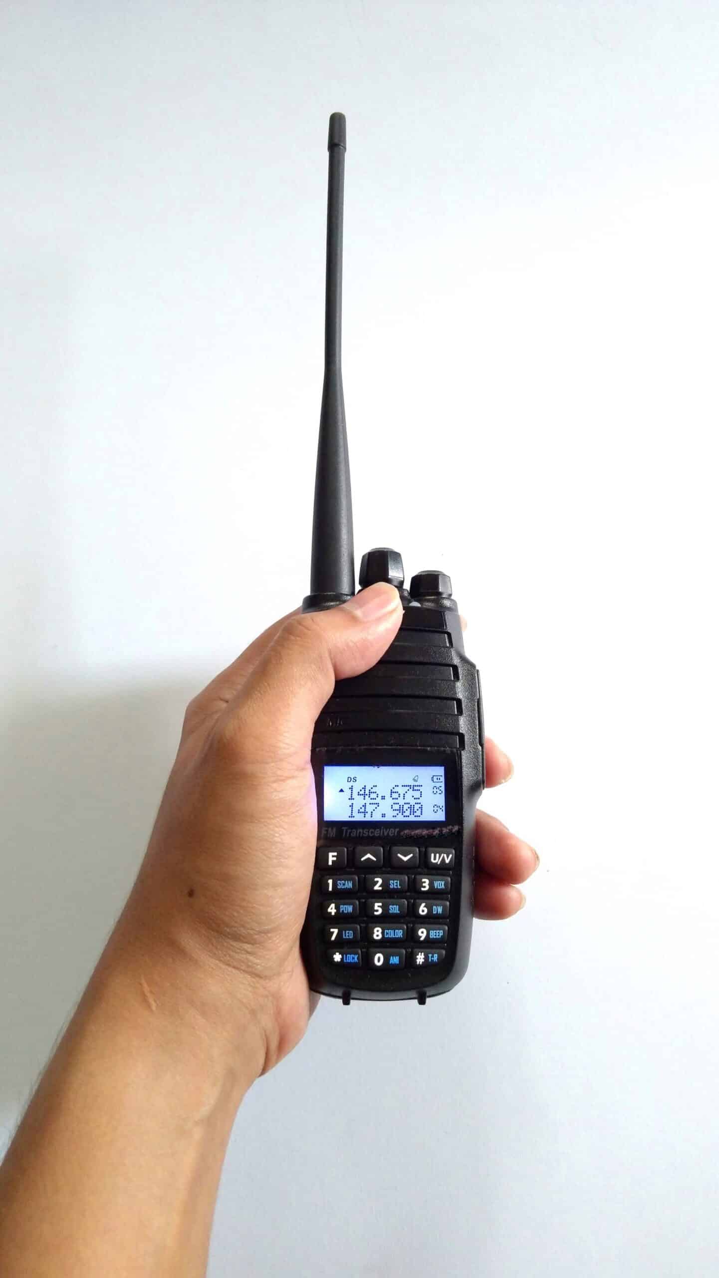 Dual-band handheld radio Hand holding a dual-band handheld radio with a 146 MHz frequency on its display