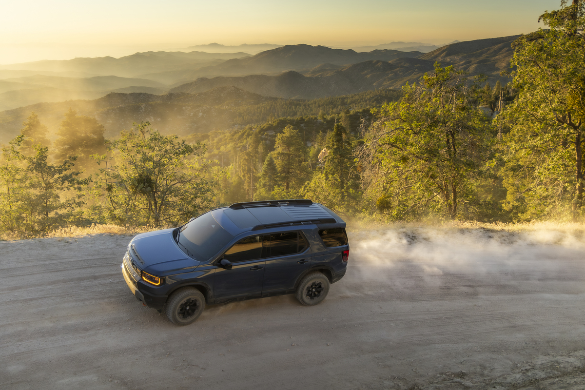 2027 Passport TrailSport on a dirt trail Dark blue 2027 Honda Passport TrailSport driving on a dirt mountain road