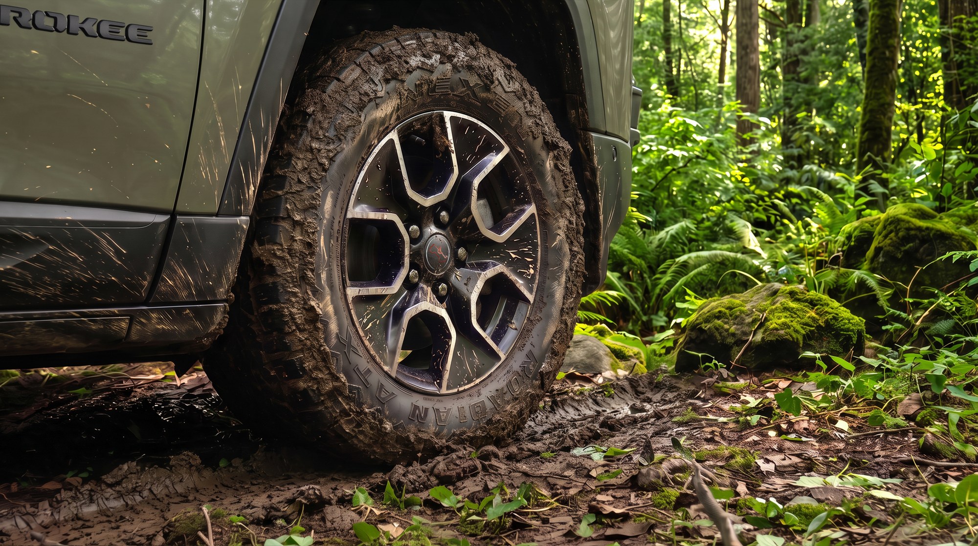 Close-up of a muddy all-terrain tire and black 17-inch wheel on a forest road