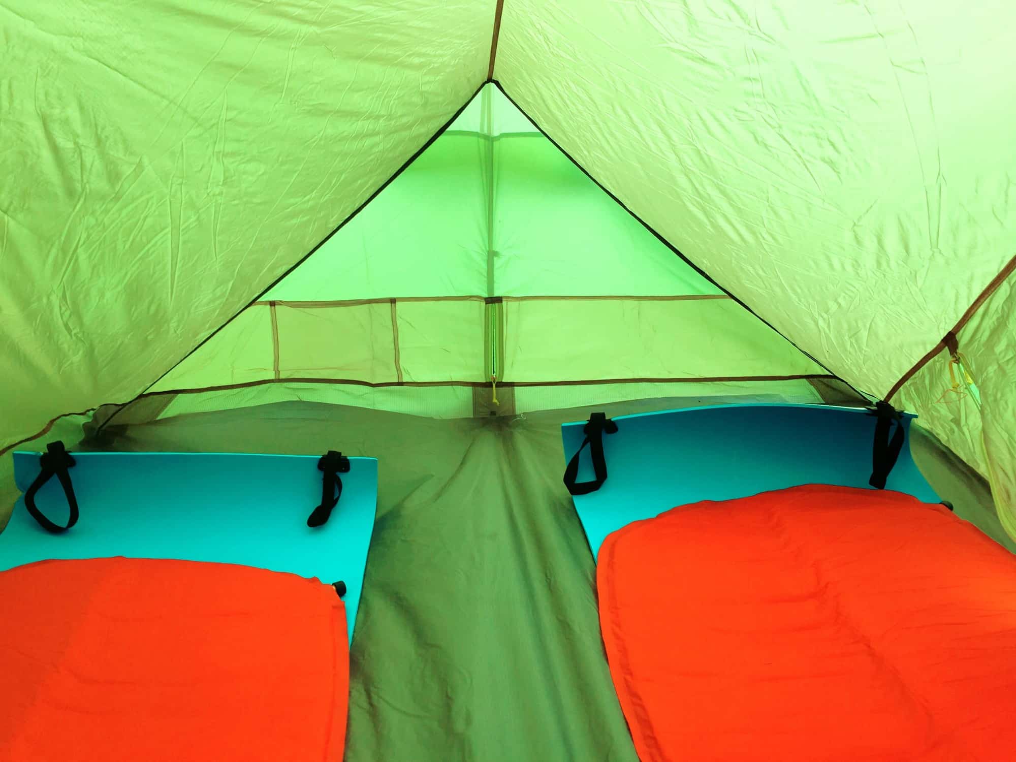 Two self-inflating sleeping pads laid out inside a small tent