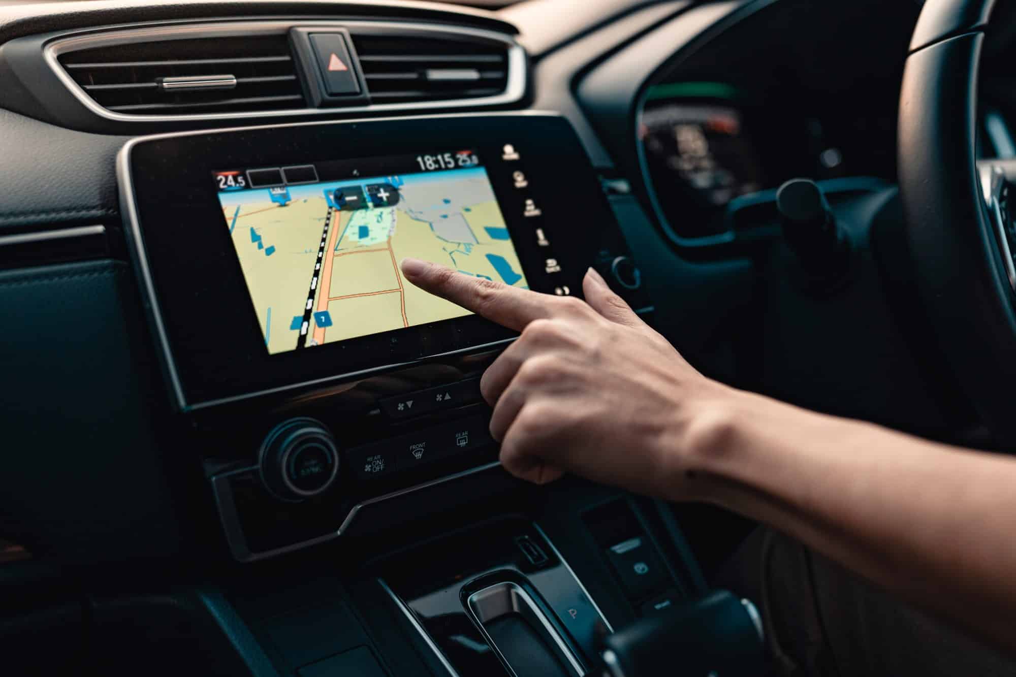 Dashboard touchscreen with navigation map Hand touching a dashboard touchscreen showing a navigation map