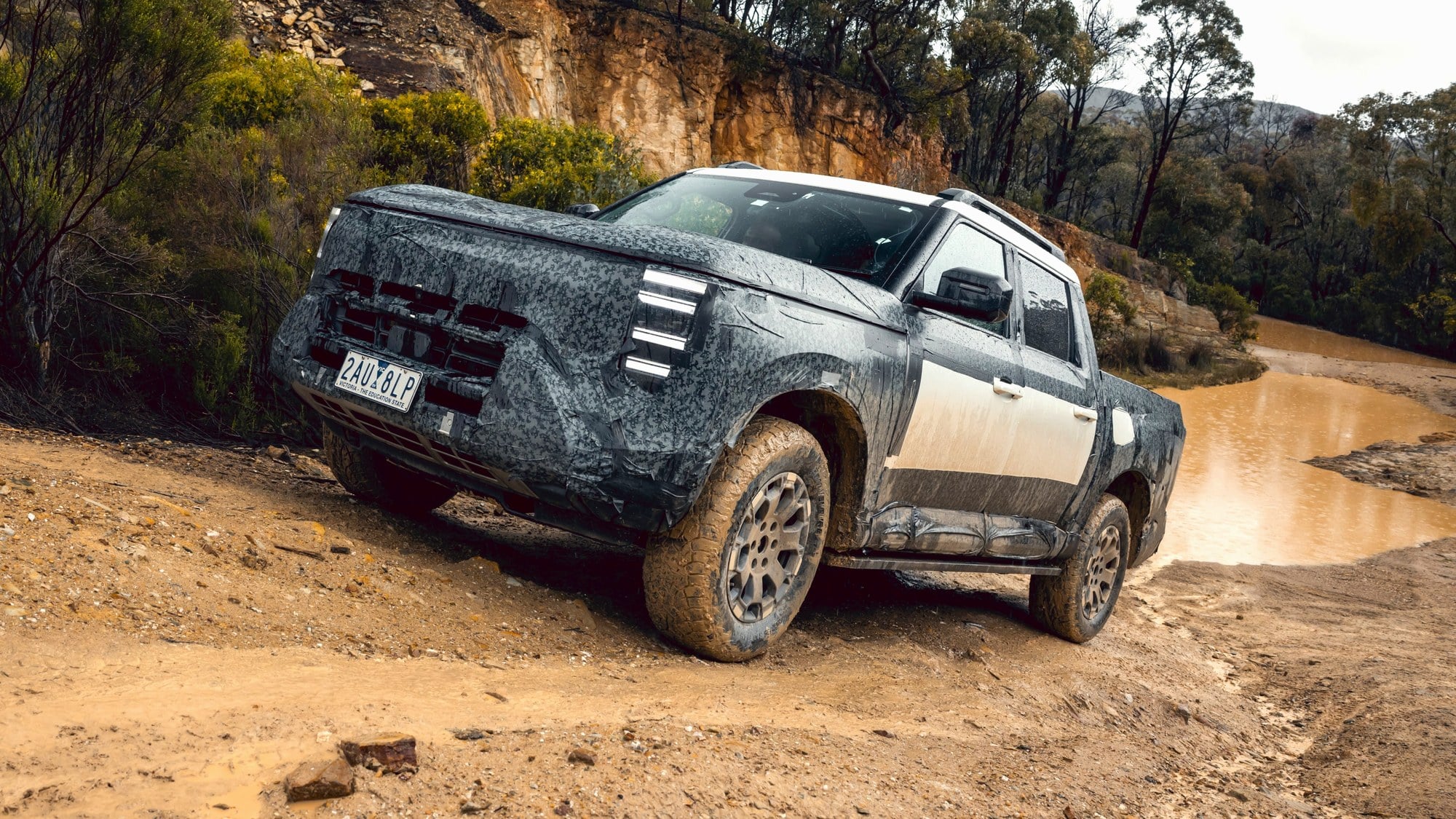 Nissan Navara Pro PHEV dual-cab 2027 Nissan Navara Pro plug-in hybrid dual-cab on a muddy quarry track