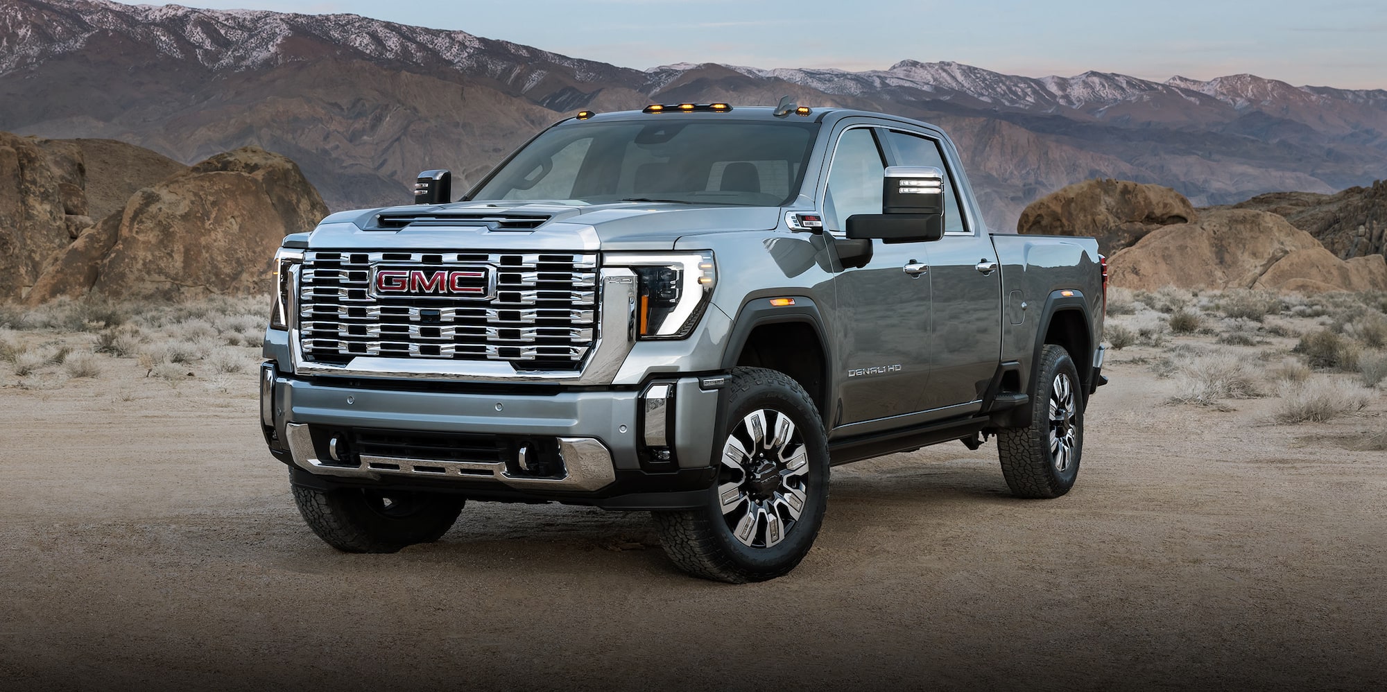 2027 Sierra HD price: gray 2027 GMC Sierra HD Denali parked on a dirt road