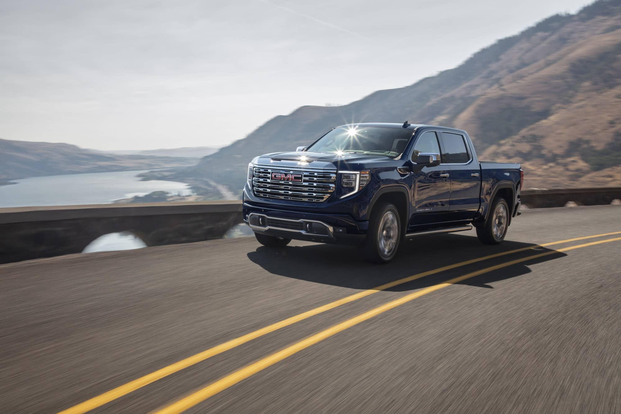 Dark blue 2022 GMC Sierra Denali on a mountain highway, a model year covered by the Sierra grille deflector recall