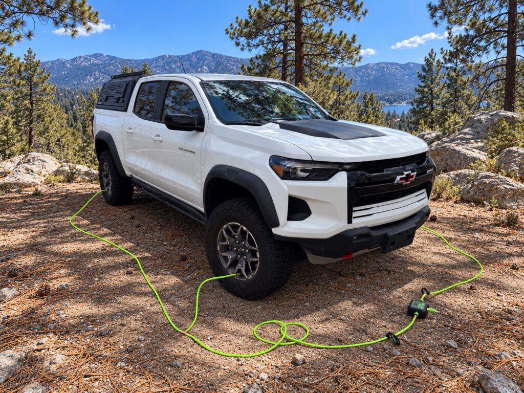 Four-Tire Air-Down Setup Four braided hoses running from the controller to each tire of a white pickup on a dirt trail