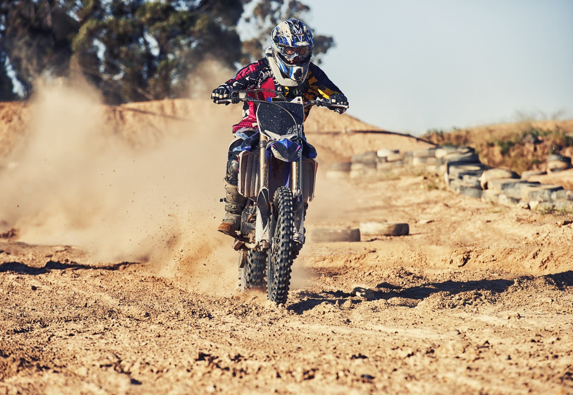 Dirt bike rider on a desert dirt track Dirt bike rider kicking up dust on a desert dirt track