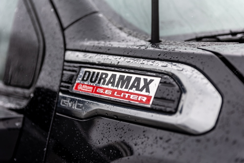 Duramax diesel engine badge with Allison Transmission logo on a black GMC heavy-duty pickup fender