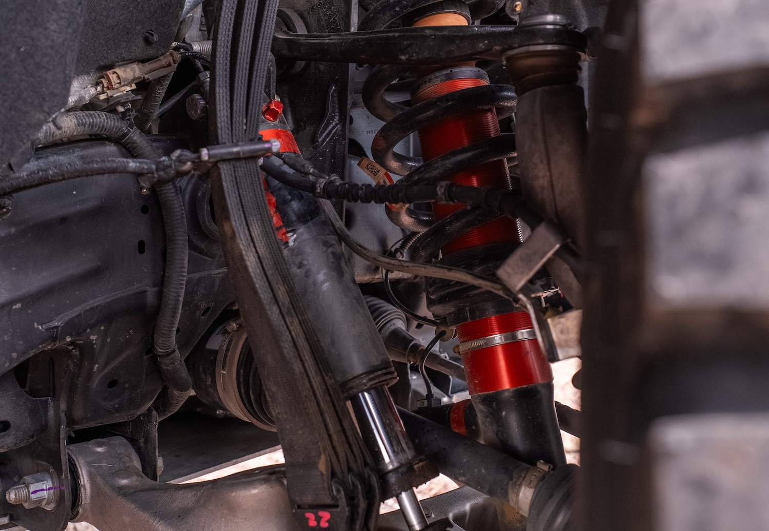 Close-up of the Baja race Bronco Raptor front suspension with a red coilover shock and control arm