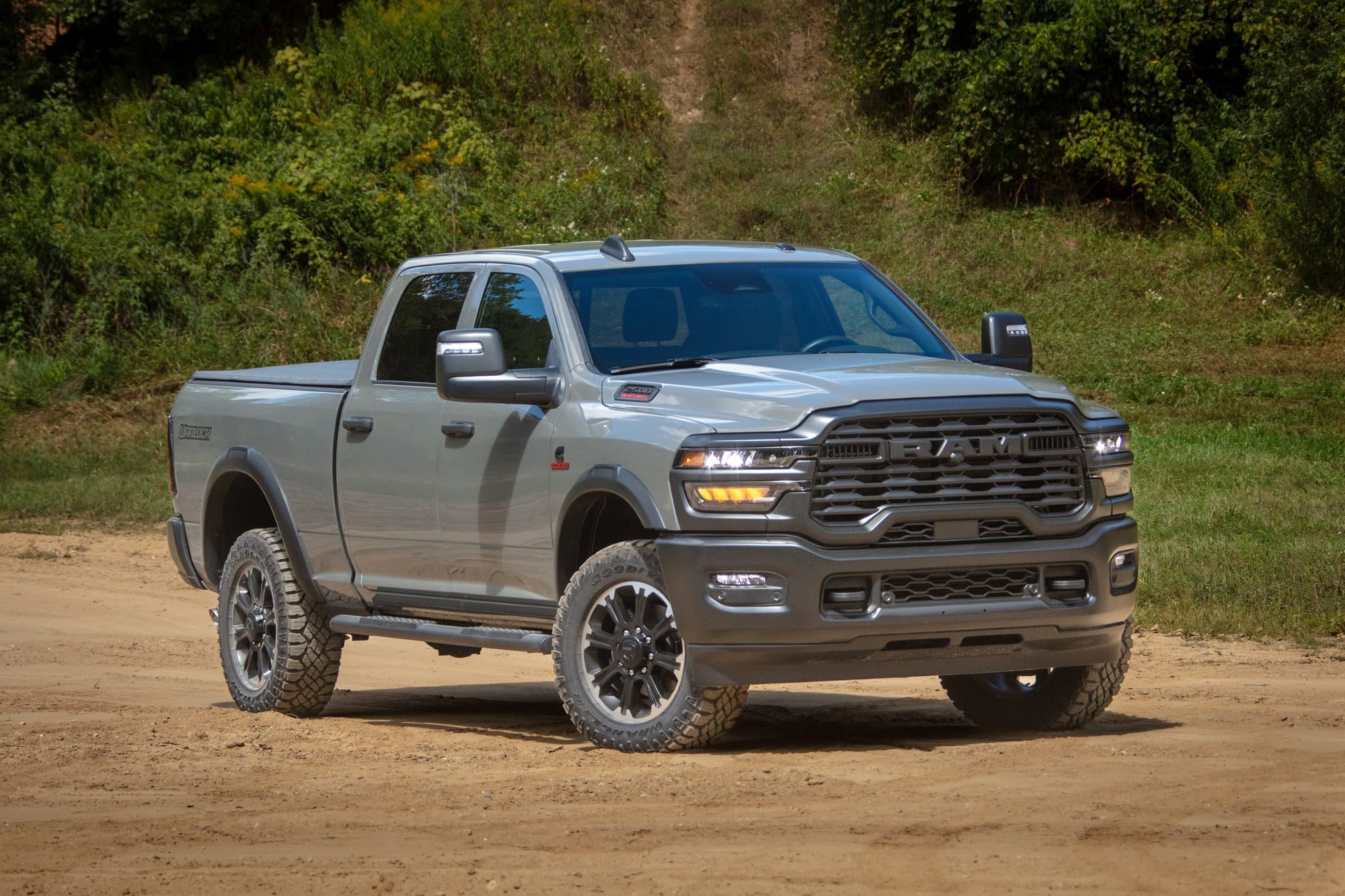 2026 Ram 2500 Warlock on a dirt trail 2026 Ram 2500 Warlock driving a dirt trail, front three-quarter view