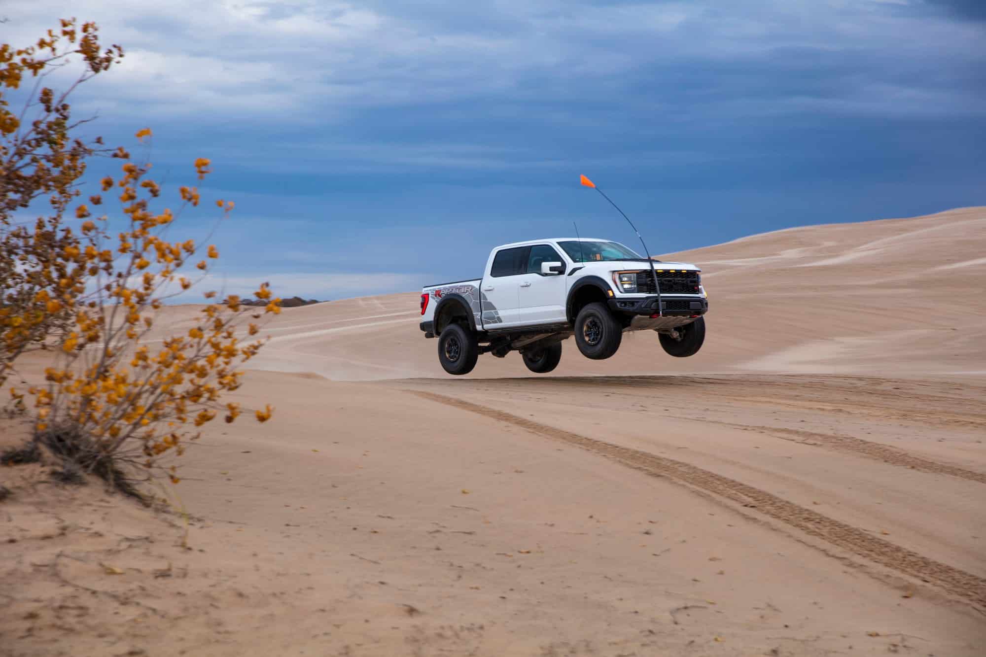 Ford F-150 Raptor R with FOX Live Valve shocks Ford F-150 Raptor R airborne on desert sand dunes with FOX Live Valve internal bypass shocks