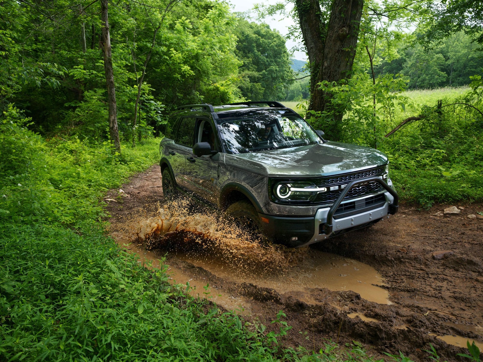Bronco Sport Badlands on a muddy trail Gray Ford Bronco Sport Badlands splashing through a muddy wooded trail
