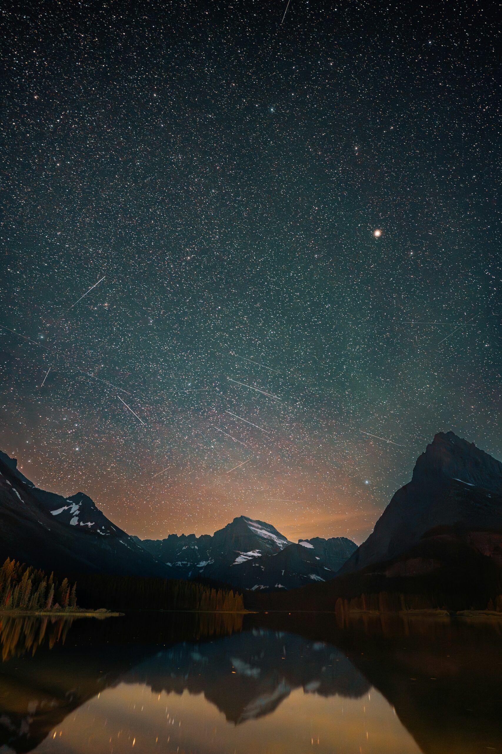 meteor shower over mountain lake