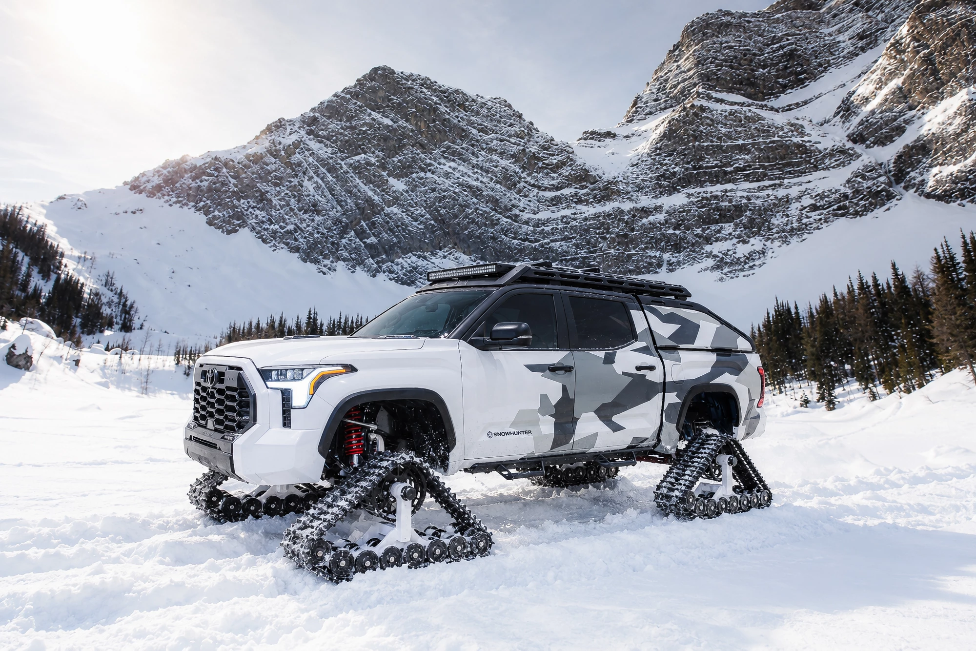 Tundra Snowhunter concept Tundra Snowhunter concept in white and gray camouflage on snow tracks below a rocky peak